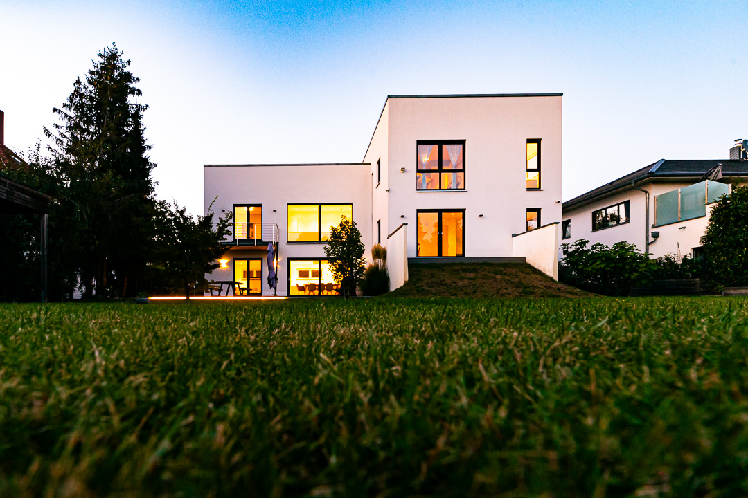 Moderne weiße Bauhausvilla in Markkleeberg am frühen Abend, aufgenommen mit leichtem Weitwinkel aus bodennaher Perspektive. Fotografiert von Sebastian Leyser.