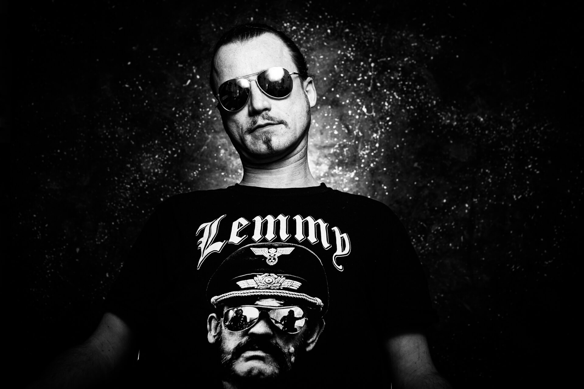 Mann mit Spiegelbrille und Lemmy-T-Shirt in ausdrucksstarker Studioaufnahme