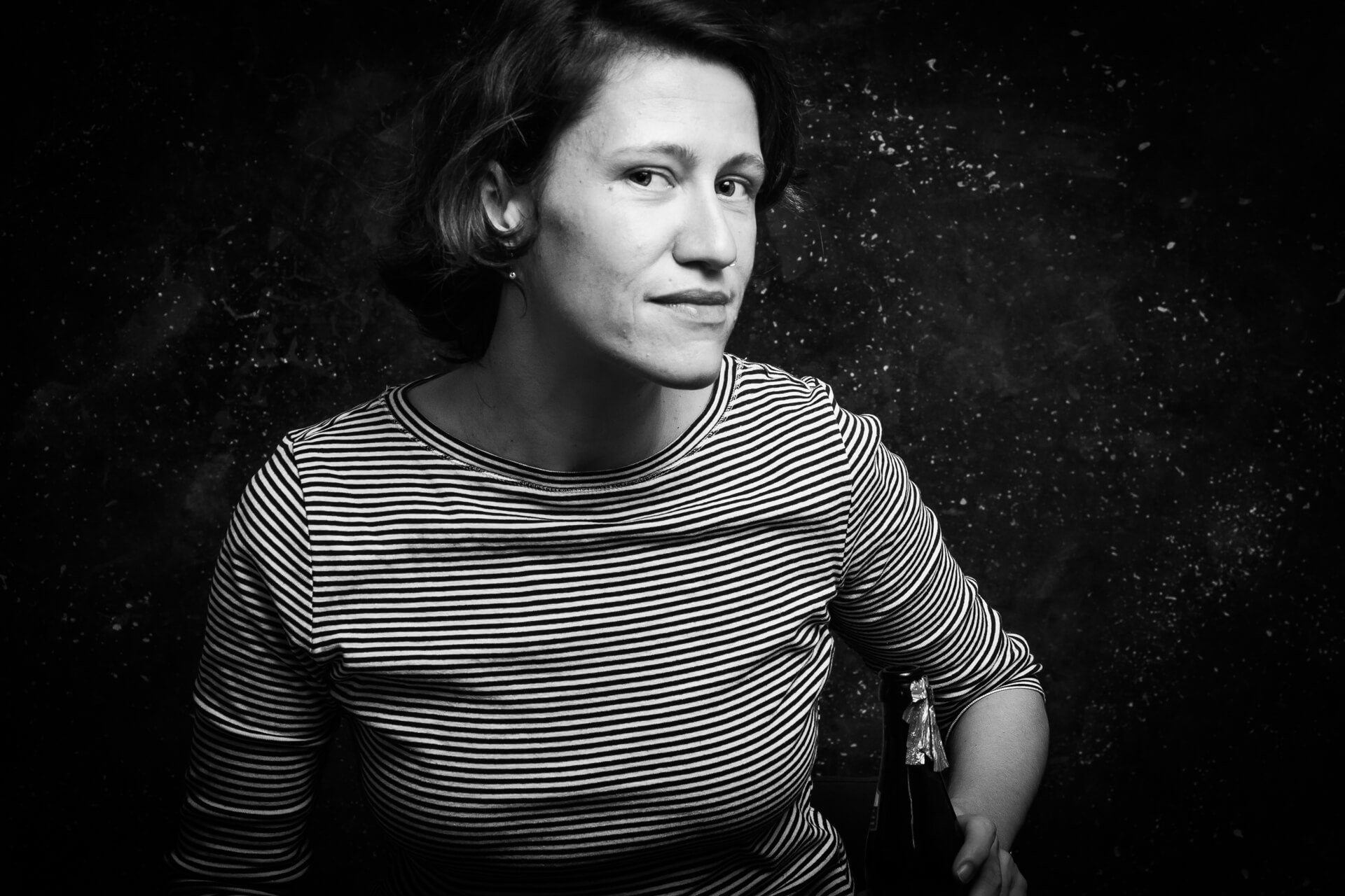 Junge Frau mit gestreiftem Shirt in ruhiger Pose, Studioaufnahme in Schwarzweiß